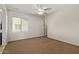 This bedroom offers neutral walls, carpet flooring, ceiling fan, and a large window to bring in natural light at 9372 W Louise Dr, Peoria, AZ 85383