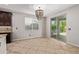 Bright dining area featuring tiled floors, a stylish chandelier, and sliding door access to the backyard at 9372 W Louise Dr, Peoria, AZ 85383