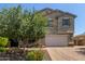 Charming stucco two-story home featuring a manicured lawn, beautiful landscaping, and a two-car garage at 9372 W Louise Dr, Peoria, AZ 85383