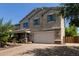 Charming two-story home with stucco exterior, a paver driveway, a two-car garage and manicured lawn at 9372 W Louise Dr, Peoria, AZ 85383