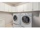 Laundry room features front loading washer and dryer with plenty of white cabinet storage at 9372 W Louise Dr, Peoria, AZ 85383