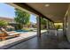 Covered patio overlooks backyard with a pool, water feature and lounge area at 9372 W Louise Dr, Peoria, AZ 85383