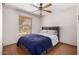Cozy bedroom featuring wood-look floors, a ceiling fan, and natural light from the window at 9714 N 55Th Dr, Glendale, AZ 85302