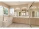 Bathroom showcasing double sinks, a large mirror with vanity lighting, tub and shower at 986 W Citrus Way, Chandler, AZ 85248