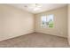 Empty bedroom with a light ceiling fan, neutral walls and carpet, and one large window at 986 W Citrus Way, Chandler, AZ 85248
