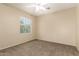 This bedroom features neutral walls and carpeting, a ceiling fan, and a large window at 986 W Citrus Way, Chandler, AZ 85248