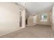 Open-concept living area with neutral walls, carpet flooring, and a view of the staircase and entry at 986 W Citrus Way, Chandler, AZ 85248