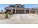 Charming two-story home with a wide driveway, desert landscaping, and a welcoming facade at 997 E White Wing Dr, Casa Grande, AZ 85122