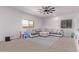 Bright and airy living room with a large sectional sofa, ceiling fan, and neutral decor at 997 E White Wing Dr, Casa Grande, AZ 85122