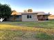 Expansive backyard with a patio set, mature trees, and a well-maintained lawn at 10726 W Kelso Dr, Sun City, AZ 85351