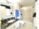 Bathroom with granite vanity, tiled walls and floors, glass shower, and natural light from the window at 10726 W Kelso Dr, Sun City, AZ 85351