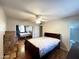 Bedroom featuring ceiling fan, wood floor, mirrored closet, and a door that leads to the bathroom at 10726 W Kelso Dr, Sun City, AZ 85351