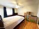Bedroom with a ceiling fan, wood floors, and a large window with curtains allowing natural light at 10726 W Kelso Dr, Sun City, AZ 85351