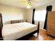 Bedroom with a ceiling fan, wood floors, and a large window with curtains allowing natural light at 10726 W Kelso Dr, Sun City, AZ 85351