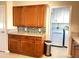 Updated kitchen cabinetry with granite counters, a mosaic backsplash, and utility area at 10726 W Kelso Dr, Sun City, AZ 85351