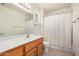 Well-lit bathroom featuring a vanity and shower with white curtain at 11033 E Keats Ave, Mesa, AZ 85209