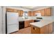 Bright kitchen with wood cabinets, white appliances and countertops, and wood-look flooring at 11033 E Keats Ave, Mesa, AZ 85209