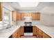 Kitchen featuring wood cabinets, white countertops, and appliances and a sunlit window at 11033 E Keats Ave, Mesa, AZ 85209