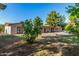 Large backyard featuring mature trees, garden, and a multi-door entrance to the home at 11143 E Vallejo St, Chandler, AZ 85248