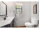 Bathroom featuring a dark vanity, white sink, and a window view of palm trees at 11143 E Vallejo St, Chandler, AZ 85248