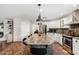 Open kitchen with a large central island, stainless appliances, and stylish lighting fixtures at 11143 E Vallejo St, Chandler, AZ 85248