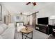Cozy living room with white couch, ceiling fan, and barn door accents, and a large TV at 11143 E Vallejo St, Chandler, AZ 85248