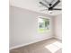 A bright, carpeted bedroom features a ceiling fan and a window letting in natural light at 1228 E Fremont Dr, Tempe, AZ 85282