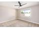A bright, carpeted bedroom features a ceiling fan and a window letting in natural light at 1228 E Fremont Dr, Tempe, AZ 85282