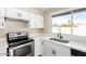 Bright kitchen features white cabinets, stainless steel appliances, and a window overlooking the backyard at 1228 E Fremont Dr, Tempe, AZ 85282