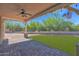 An outdoor living space boasts a covered patio with fan and lights, desert landscaping, and a lush lawn at 1336 E Belmont Ave, Phoenix, AZ 85020