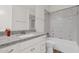 Bright bathroom featuring a granite countertop, vanity with drawers, and a shower/tub combo with decorative wall tiles at 1336 E Belmont Ave, Phoenix, AZ 85020