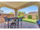 Charming covered patio with brick flooring, outdoor seating, and a view of the manicured backyard at 14200 W Village Pkwy # 2128, Litchfield Park, AZ 85340