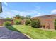 Well-maintained backyard featuring lush artificial turf, vibrant plants, and a charming brick perimeter at 14200 W Village Pkwy # 2128, Litchfield Park, AZ 85340