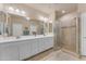 Bathroom boasts double sinks, a large mirror, and a walk-in shower at 14200 W Village Pkwy # 2128, Litchfield Park, AZ 85340