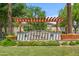 Elegant community entrance with manicured landscaping, stone signage, and a welcoming pergola at 14200 W Village Pkwy # 2128, Litchfield Park, AZ 85340