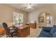 Home office has a large desk and natural light from the window at 14200 W Village Pkwy # 2128, Litchfield Park, AZ 85340
