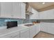 Modern kitchen featuring white cabinetry, stainless steel appliances, and a stylish blue tile backsplash at 14200 W Village Pkwy # 2128, Litchfield Park, AZ 85340