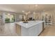 Open-concept kitchen island with bar seating, connecting to the living room and outdoor patio for seamless entertaining at 14200 W Village Pkwy # 2128, Litchfield Park, AZ 85340