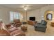 Cozy living room featuring leather furniture, tile flooring, and plantation shutters for a relaxed atmosphere at 14200 W Village Pkwy # 2128, Litchfield Park, AZ 85340
