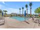 Resort-style pool area with ample lounge seating, palm trees, and inviting clear blue water at 14200 W Village Pkwy # 2128, Litchfield Park, AZ 85340
