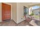 Inviting front porch with a red door, brick pavers, and comfortable seating under a covered entry at 14200 W Village Pkwy # 2128, Litchfield Park, AZ 85340