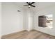 Bright bedroom with a ceiling fan, closet, light wood floor, and a window overlooking the front yard at 15226 S 14Th Dr, Phoenix, AZ 85045