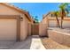 Side view of a home featuring a gated entrance and two-car garage with desert landscape at 15226 S 14Th Dr, Phoenix, AZ 85045