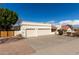 Low angle captures the three-car garage and beige stucco exterior with lovely landscaping against a blue sky at 15602 N 19Th St, Phoenix, AZ 85022