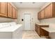 Well-lit laundry room with ample cabinet space, washer, dryer, and folding table at 15602 N 19Th St, Phoenix, AZ 85022