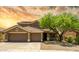 Inviting two-story home featuring a three-car garage, desert landscaping, and a covered porch at 17493 W Arroyo Way, Goodyear, AZ 85338