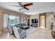 Inviting living room features a ceiling fan, tile floors, and large windows overlooking the backyard pool at 17493 W Arroyo Way, Goodyear, AZ 85338