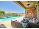 Covered patio with comfortable seating and a view of the sparkling pool at 17493 W Arroyo Way, Goodyear, AZ 85338