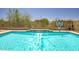 A beautiful pool with a water feature, basketball hoop, and lush landscaping at 17493 W Arroyo Way, Goodyear, AZ 85338