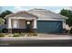 Charming single-story home featuring stone accents, a blue garage door, and a well-maintained front yard at 17595 W Monroe St, Goodyear, AZ 85338